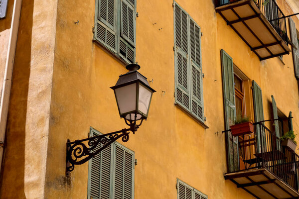 A street lamp has been mounted on the facade of the building, as seen here in the old town of Nice, Cote d'Azur, Franc