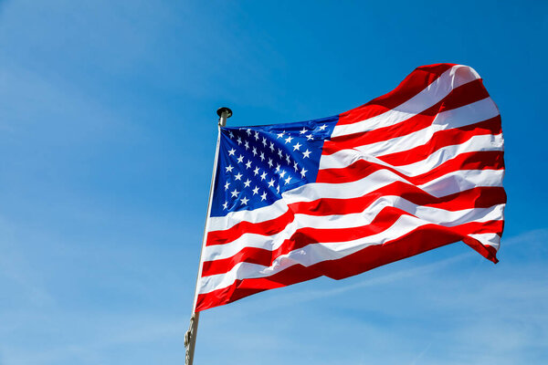 Flag of the United States of America waving in blue sky in Nice, France.