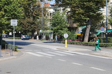 Varşova, Polonya - 13 Eylül 2023: Bir sokak, bir yaya geçidi, bir otobüs durağı, evler ve Praga-Poludnie 'deki Saska Kepa konutlarındaki birçok doğa