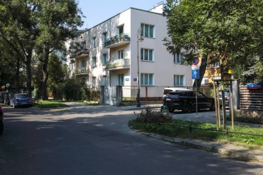 Varşova, Polonya - 13 Eylül 2023: Praga-Poludnie bölgesindeki Saska Kepa konutlarının kavşağındaki yakındaki ağaçların gölgesinde ev.