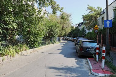Varşova, Polonya - 13 Eylül 2023: Trafiği olmayan dar bir cadde ama Praga-Poludnie 'deki Saska Kepa konutlarında park halindeki bir sıra araba.