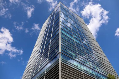 Varşova, Polonya - 1 Eylül 2023: Central Point adındaki bu modern, çok katlı ofis binası şehir merkezinde ve güneşli bir günde birkaç bulutlu mavi gökyüzüne karşı görüyoruz..