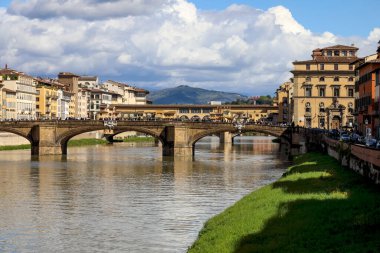 Floransa, İtalya - 15 Nisan 2023: Arno Nehri, binaları ve köprüleri burada görülen şehrin içinden akar. Eski köprü Ponte Vecchio, Ponte Santa Trinit köprüsünün arkasında görüldü.