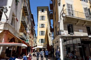 Güzel, Fransa - 25 Nisan 2023: iki dar cadde arasında dar cepheli uzun bir kasaba evi var. Gerek turistler gerekse halk kentin eski kesiminde çok sayıda restoran, kafe ve mağaza bulacaklar.