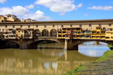 Floransa, İtalya - 15 Nisan 2023: Ortaçağ ikonik Eski Köprüsü 'nün ortası, Arno Nehri' ni geçen Ponte Vecchio. Uzakta bir grup insanı köprüde görebilirsiniz.