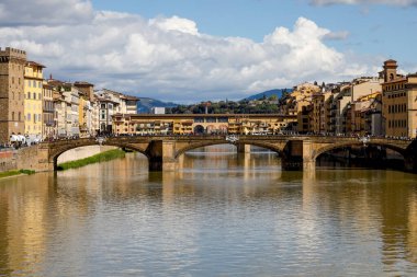 Floransa, İtalya - 15 Nisan 2023: Arno Nehri, binaları ve köprüleri burada görülen şehrin içinden akar. Eski köprü Ponte Vecchio, Ponte Santa Trinit köprüsünün arkasında görüldü.