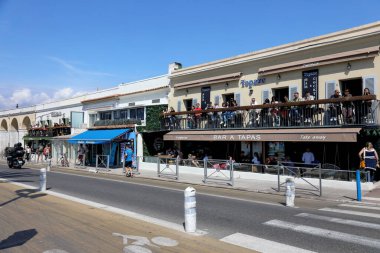 Güzel, Fransa - 23 Nisan 2023: deniz kenarında iki katlı binalar. Bu binaların hem kaldırımlarda hem de balkonlarda veya teraslarda açık hava restoranları var..