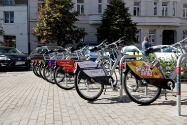 Varşova, Polonya - 20 Eylül 2023: Bisikletler şehir merkezinde bir paylaşım istasyonuna park edildi. Bu tür motorları kullanmak çevreyi korumak ve egzoz kirliliğini azaltmak için mükemmel bir yoldur.