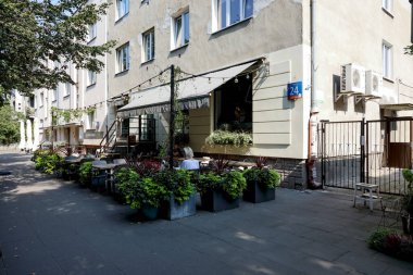 Varşova, Polonya - 12 Eylül 2023: Apartman bloklarının yanındaki açık hava restoranı neredeyse boş, Saska Kepa konutlarında gördüğünüz gibi koltukların çoğu henüz boş.