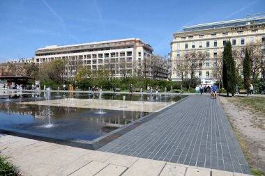 Nice, France - April 28, 2023: Modern, large and flat fountain, part of the Promenade du Paillon. Nearby buildings in the city centre are also visible. clipart