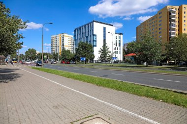 Varşova, Polonya - 23 Ağustos 2023: Praga-Poludnie bölgesindeki Goclaw konutlarının bir parçası olarak güneşli bir günde, doğaya yakın binalar ve caddeler.