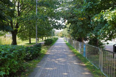 Polonya 'nın Varşova, Praga-Poludnie bölgesindeki Goclaw konutlarının kamu parkından dar bir ara sokak geçiyor..