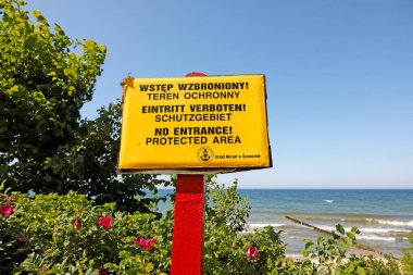 Ustronie Morskie, Polonya - 22 Mayıs 2024: Sarı panoda giriş yok, koruma bölgesi yazıyor. Bir doğa rezervi, Baltık Denizi sahillerinin kumulları. Tahtada Denizcilik Ofisi damgası var..