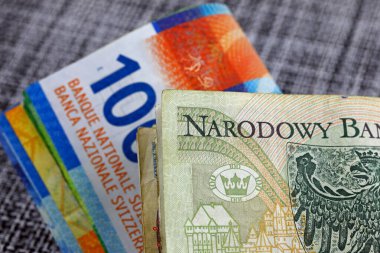 Polonya ve İsviçre parası. Polonya zloti banknotları İsviçre banknotlarının yanında. Bu tema birçok farklı finansal konuları göstermek için kullanılabilir. PLN ve CHF para birimleri