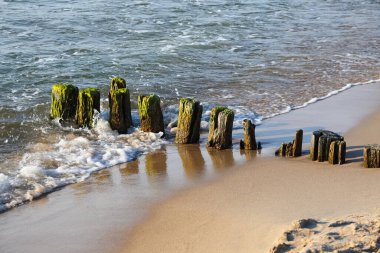 Yıpranmış dalgalar, Polonya 'nın Batı Pomeranya bölgesindeki Ustronie Morskie' deki Baltık Denizi kıyılarında meydana gelen zararlı etkilere karşı kıyıları koruyor.