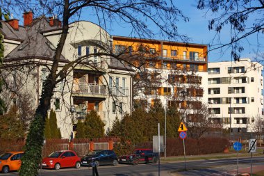 Varşova, Polonya - 30 Ocak 2024: Praga-Poludnie 'nin bir alt bölgesi olan Goclaw' daki konut binaları, güneşli bir kış günlerinde ağaçların arkasında görülebilir..