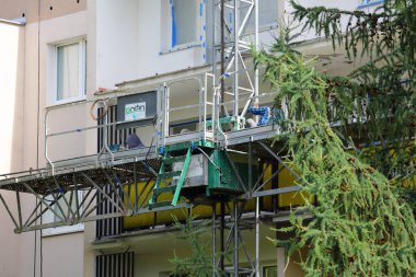 Varşova, Polonya - 8 Ağustos 2024: Praga-Poludnie bölgesindeki Goclaw konutlarındaki balkonlarının modernizasyonu sırasında binanın ön cephesinin bir parçası.