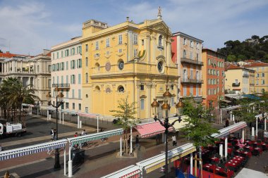 Nice, France - April 21, 2023: The city market on Cours Saleya, with its striped roofs that shield the stalls from the sun, finished its work today. The sacred building visible is the Chapel of Mercy clipart