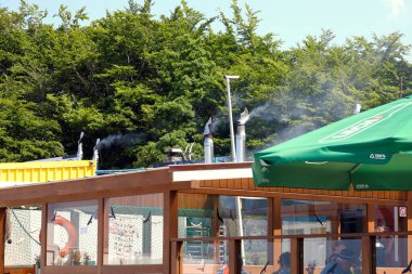 Ustronie Morskie, Poland - May 30, 2024: Smoke comes out of the chimneys. Many types of fish are smoked in these coastal smokehouses. clipart