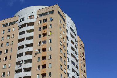 Warsaw, Poland - April 11, 2024: Upper part of a block of flats against a blue sky in the Goclaw housing estate in the Praga-Poludnie district clipart