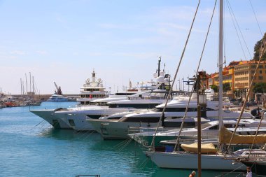 Nice, Fransa - 23 Nisan 2023 Port Lympia 'da birbirine bağlanmış çeşitli boyutlarda lüks yatlar. Şehirdeki binalar biraz daha görünür.