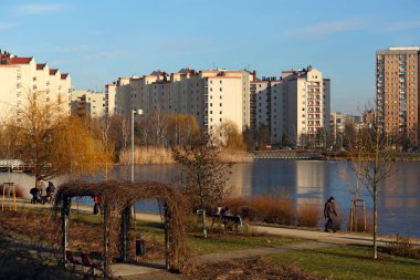Varşova, Polonya - 30 Ocak 2024: Praga-Poludnie 'nin bir alt bölgesi olan Goclaw' da karsız kış mevsiminde donmakta olan bir gölün arkasındaki uzun apartman blokları.