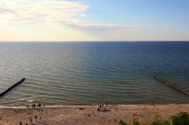 Ustronie Morskie, Polonya - 29 Mayıs 2024: Baltık Denizi sahilinin akşamları havadan görünüşü, deniz kenarında güneşlenmek ve dinlenmek için bir yer. Günün bu saatinde kumda çok fazla tatilci olmaz..