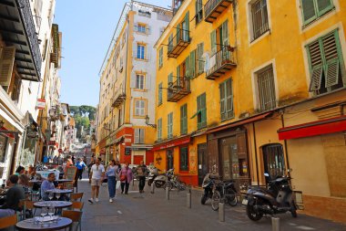 Nice, Fransa - 25 Nisan 2023: Çeşitli açık kafe ve restoranların bulunduğu dar sokaklardaki evler, dükkanlar ve diğer ayrıntılar genellikle pek çok kişi tarafından hevesle ziyaret edilir