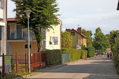 Ustronie Morskie, Polonya - 28 Mayıs 2024: Dar sokakta evler var. Burası bu kasabaya gelen tatilciler için misafir odaları sunuyor.