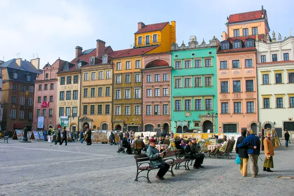 Varşova, Polonya - 24 Mart 2005: Eski Kasaba Pazar Meydanı, bazılarını burada gördüğümüz renkli ve geleneksel binalarla çevrilidir. İnsanlar buraya yürümek, rahatlamak ve anıtları görmek için geliyor..