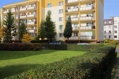Varşova, Polonya - 30 Ekim 2023: Yeşil çimlerin arkasında Praga-Poludnie bölgesindeki Goclaw konutlarında bir apartman bloğu var.