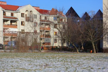 Varşova, Polonya - 8 Ocak 2024: Praga-Poludnie bölgesindeki Goclaw konutlarında, hafif karla kaplı çimlerin arkasında bir apartman bloğu