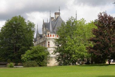 Azay le Rideau, Fransa - 12 Haziran 2010: Kaleyi çevreleyen ağaçların yapraklarıyla kısmen gizlenmiş bir kale manzarası.