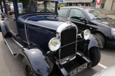 Saumur, Fransa - 13 Haziran 2010: 1928 ve 1932 yılları arasında yapılmış klasik bir Citroen C4, diğer modern otomobiller arasında açık hava parkında park edilmiş olarak görülebilir..