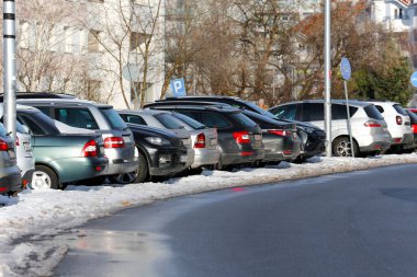 Varşova, Polonya - 19 Ocak 2024: Praga-Poludnie bölgesinin Goclaw bölgesinde güneşli bir kış gününde bir otoparkta yan yana park edilmiş bir grup araba.