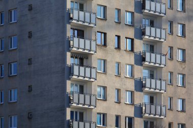 Varşova, Polonya - 8 Ocak 2024: Praga-Poludnie bölgesinin Goclaw bölgesinde güneşli bir günde güneşle aydınlatılan büyük bir apartman bloğunun balkonlu ön cephesi.