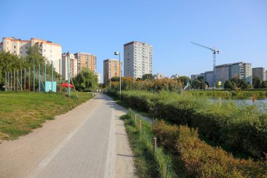 Varşova, Polonya - 10 Eylül 2023: Praga-Poludnie bölgesindeki Goclaw konutlarında bir kamu parkı ile apartman blokları bir arada yaşanıyor