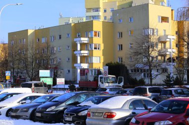 Varşova, Polonya - 19 Ocak 2024: Praga-Poludnie bölgesinin Goclaw bölgesinde güneşli bir kış gününde, açık hava otoparkında yan yana park edilmiş farklı arabalardan oluşan bir grup..