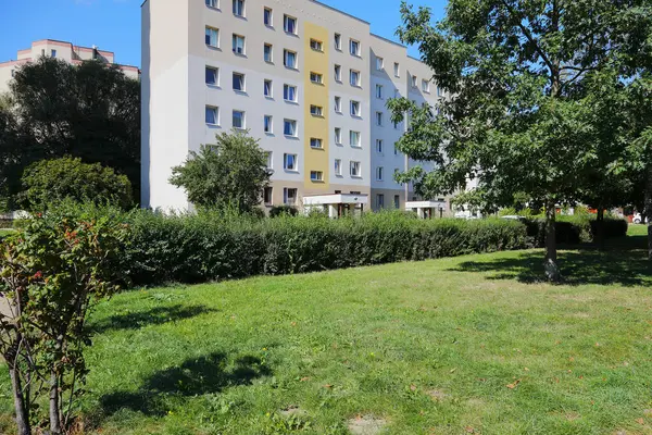 Varşova, Polonya - 15 Eylül 2023: Praga-Poludnie bölgesindeki Goclaw konutlarında yeşil çimlerin arkasında bir apartman bloğu görülebilir.