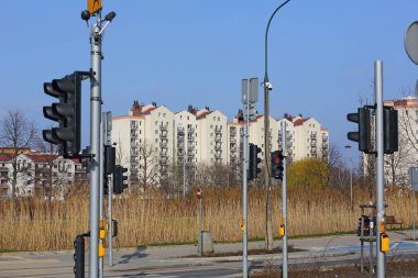 Varşova, Polonya - 14 Mart 2024: Praga-Poludnie 'nin Goclaw alt bölgesinde karsız bir kış mevsiminde trafik ışıkları ve kuru sazlıkların arkasındaki apartman blokları