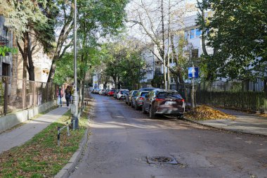 Varşova, Polonya - 1 Kasım 2023: Arabalar Praga-Poludnie 'nin Saska Kepa alt bölgesinde dar cadde boyunca park halindedir. Evler de görülebilir.
