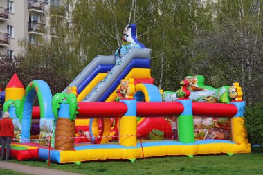 Varşova, Polonya - 6 Nisan 2024: Praga-Poludnie bölgesindeki Goclaw konutlarının bir parçası olan parkta bu bahar renkli şişme bir oyun alanı inşa edildi.