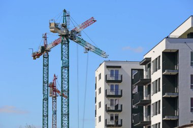 Varşova, Polonya - 11 Nisan 2024: Praga-Poludnie bölgesindeki Goclaw konutlarında bir inşaat alanında çalışan bir grup turna kuşu mavi gökyüzüne karşı görülebilir