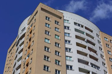 Varşova, Polonya - 11 Nisan 2024: Praga-Poludnie bölgesindeki Goclaw konutlarında mavi gökyüzüne karşı bir apartman bloğunun üst kısmı