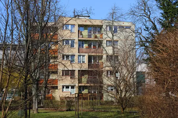 stock image Warsaw, Poland - March 9, 2024: Block of flats behind leafless trees on Brazylijska Street in a snowless winter in the Saska Kepa sub-district of Praga-Poludnie on a sunny day.