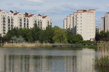 Varşova, Polonya - 28 Nisan 2024: Praga-Poludnie 'nin Goclaw alt bölgesinde apartman bloklarıyla çevrili bir göl.