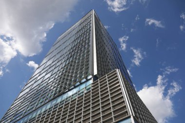 Varşova, Polonya - 1 Eylül 2023: Central Point adlı modern çok katlı bir ofis binası şehir merkezinde yer almakta ve burada güneşli bir günde birkaç bulutlu mavi bir gökyüzüne karşı görüyoruz.