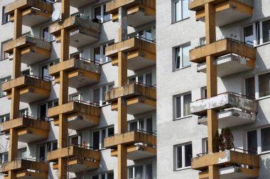 Warsaw, Poland - March 14, 2024: Partial view of the facade of a block of flats with balconies in the Goclaw sub-district of Praga-Poludnie. clipart