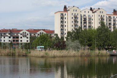 Varşova, Polonya - 28 Nisan 2024: Praga-Poludnie 'nin Goclaw alt bölgesinde apartman bloklarıyla çevrili bir göl. 