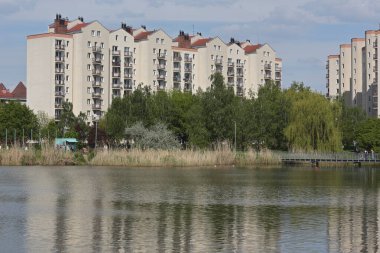 Varşova, Polonya - 28 Nisan 2024: Praga-Poludnie 'nin Goclaw alt bölgesinde apartman bloklarıyla çevrili bir göl. 